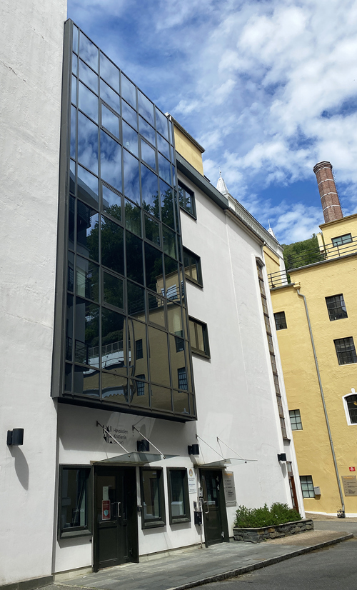 Foto av fasade med store vinduer.