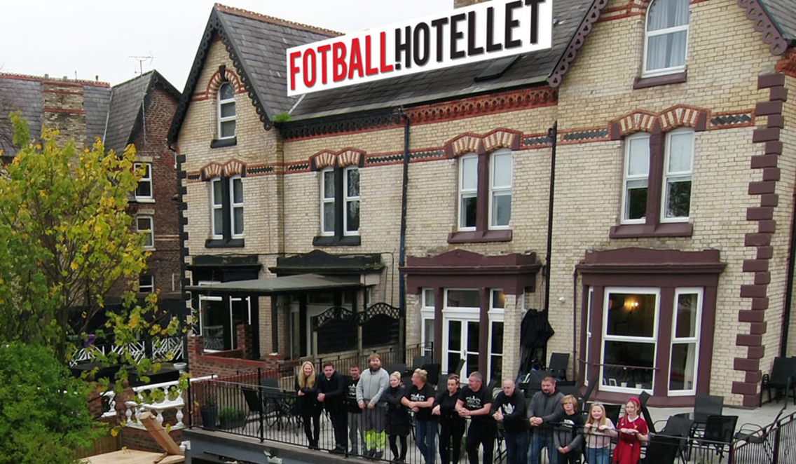 Charlotte Eide har designet logoen til Fotballhotellet som pryder taket til hotellet, en eldre murbygning. På balkongen foran hotellet står en gruppe mennesker på rekke og rad, som lener seg over rekkverket.