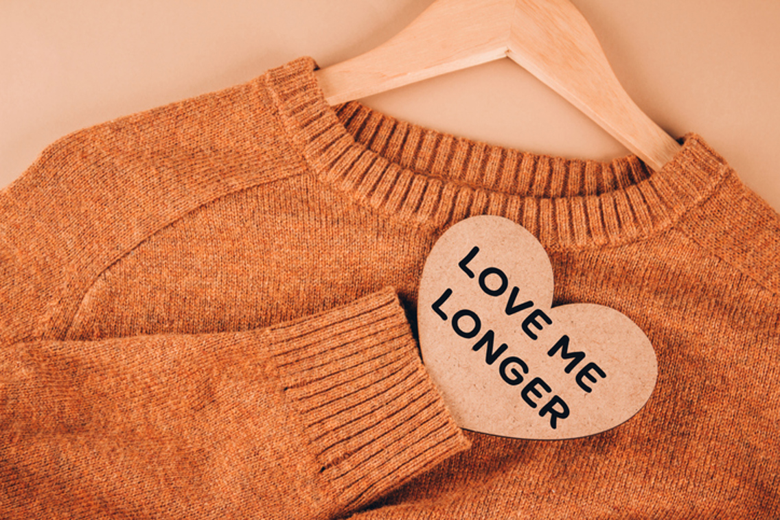 Orange woolen sweater with a heart saying love me longer
