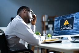 En mann ser fortvilet på pc-skjermen sin som er blitt hacket