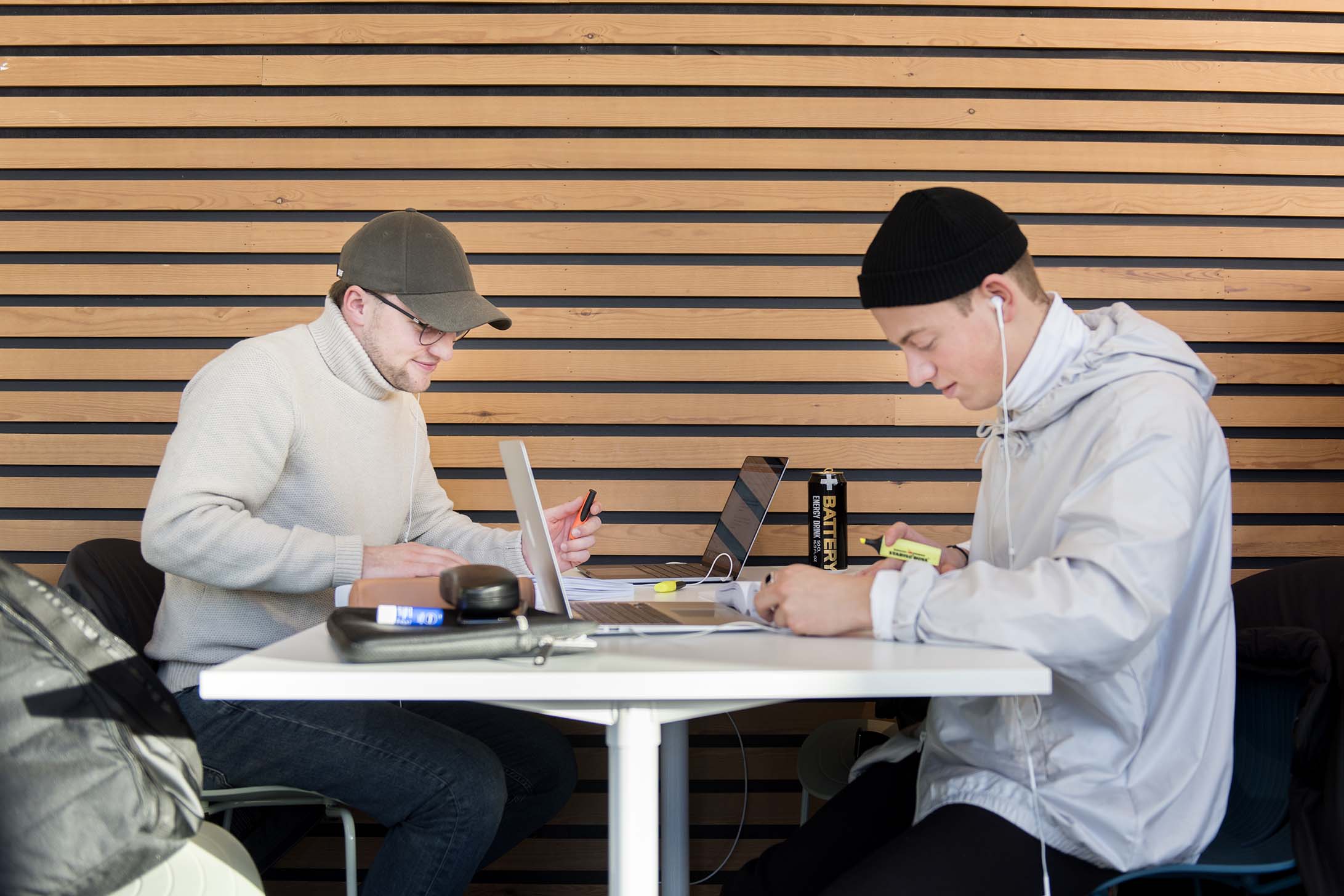 Foto av to mannlige studenter ved et bord.
