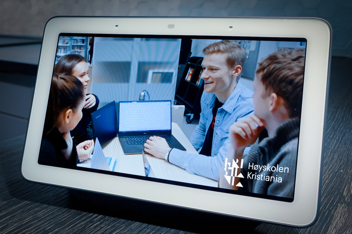 Foto av nettbrett som viser fire studenter rundt en PC.