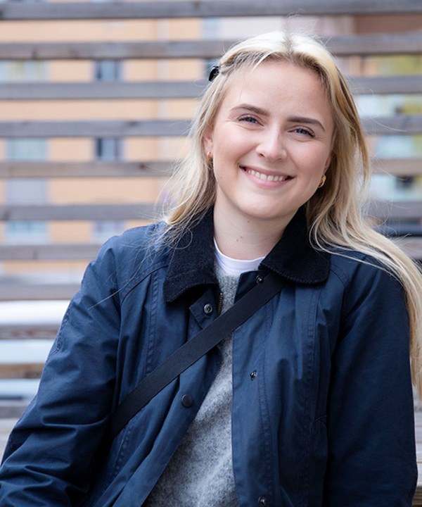Portrett av Kristiane Lunde som  smiler til kamera. Hun har på seg en blå jakke.