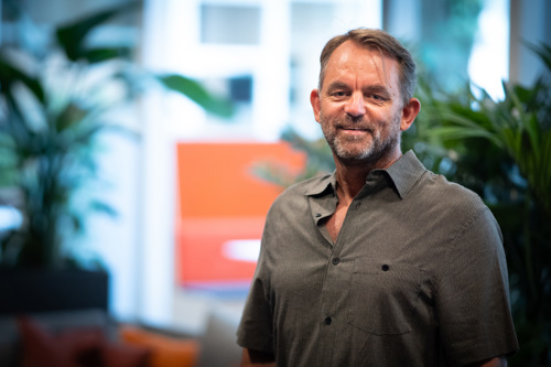 Andreas Norgår Thon smiler ved hovedinngangen til Kristiania campus Oslo.