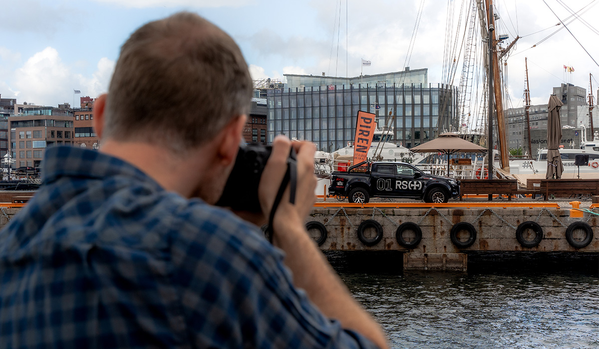 Foto av mann som tar bilde av en bil som står på en brygge.