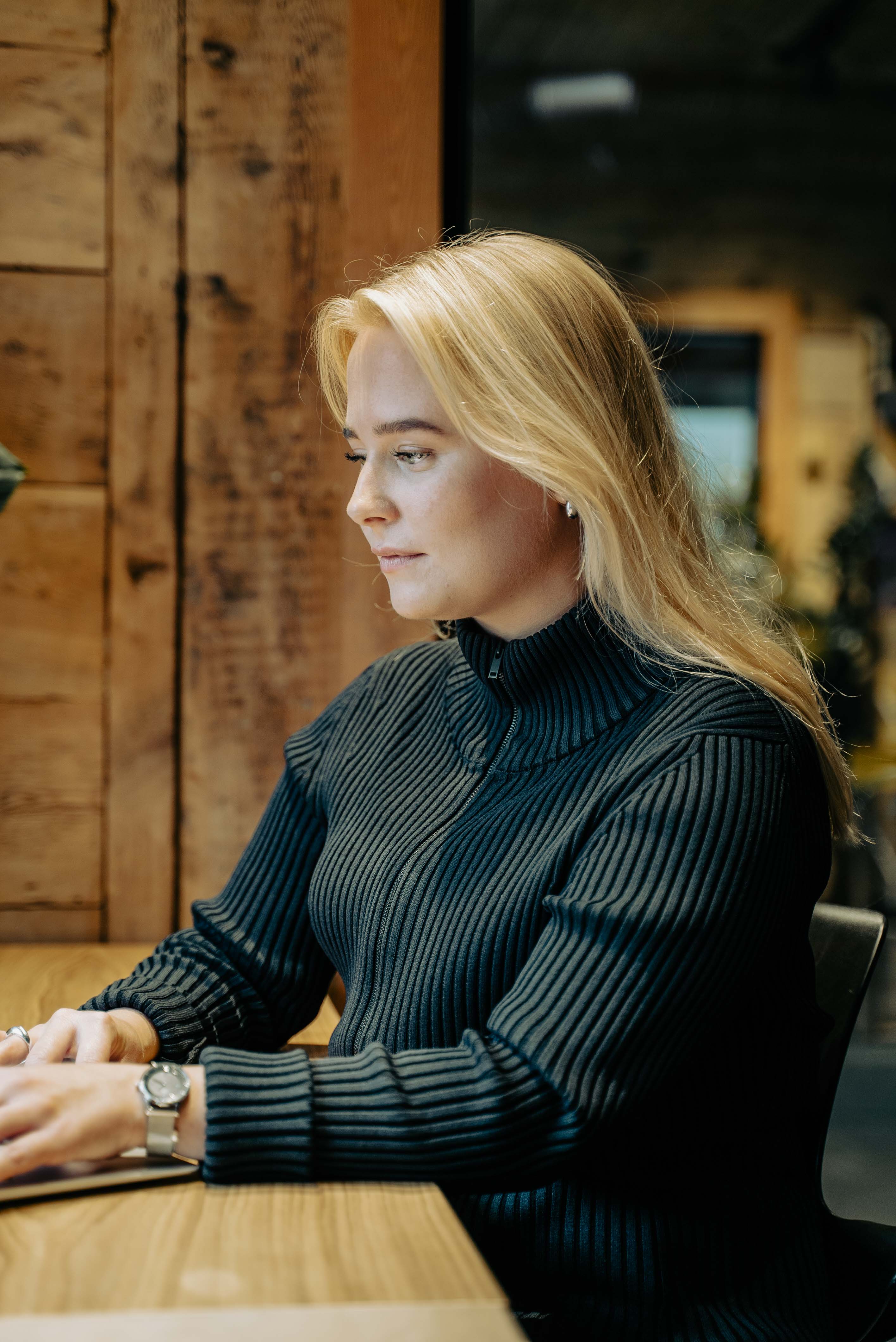 Foto av en kvinne som sitter ved kontorpulten på en laptop og jobber.
