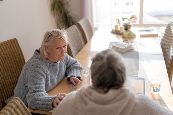 To personer i en samtale i et hjemmekoselig miljø