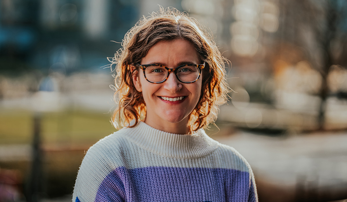 Portrettfoto av Stefanie Dziadkowiec som står ute og smiler til kamera. 