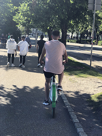Foto av ung mann som sykler på en bysykkel.