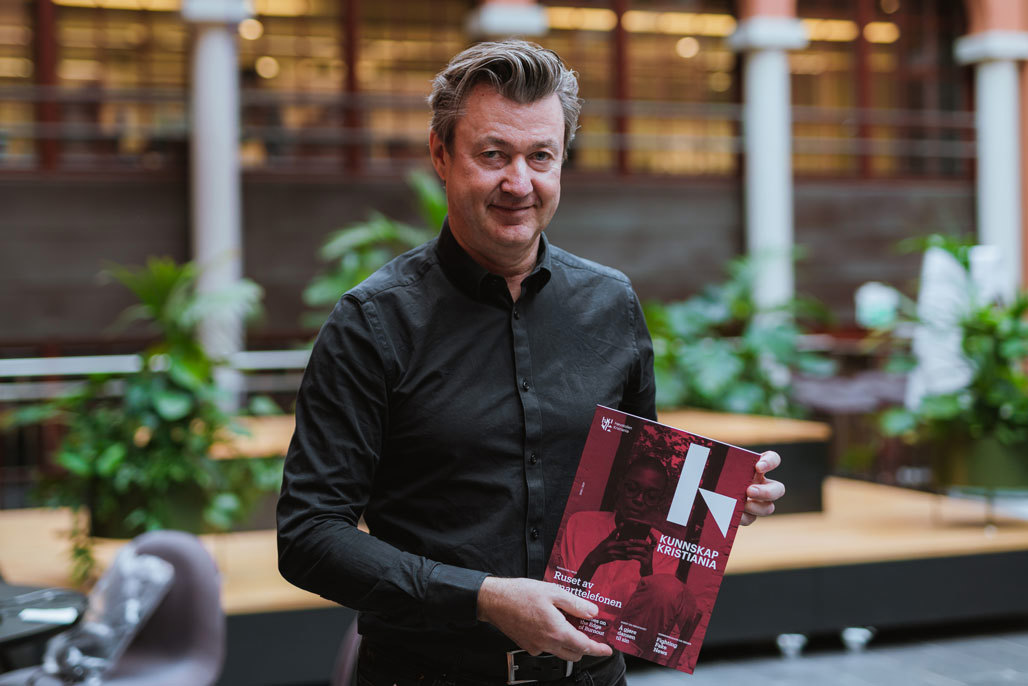 Mann holder opp jubileumsmagasin.