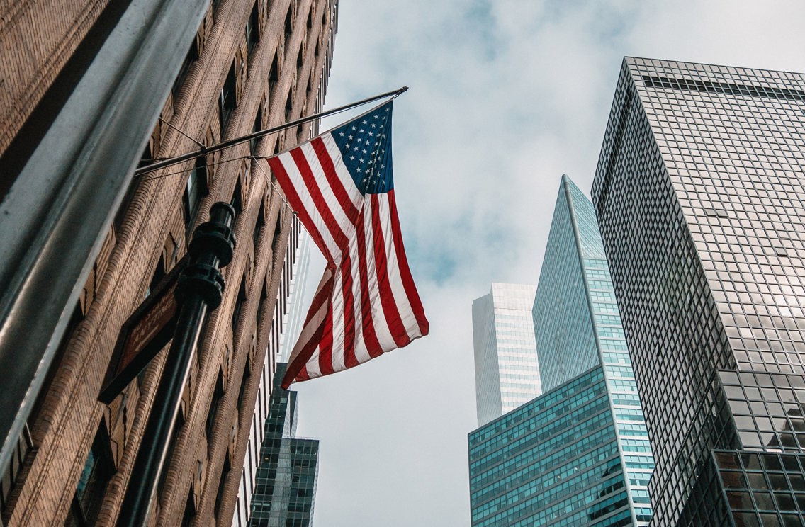 Det amerikanske flagget på stang på en bygning i New York