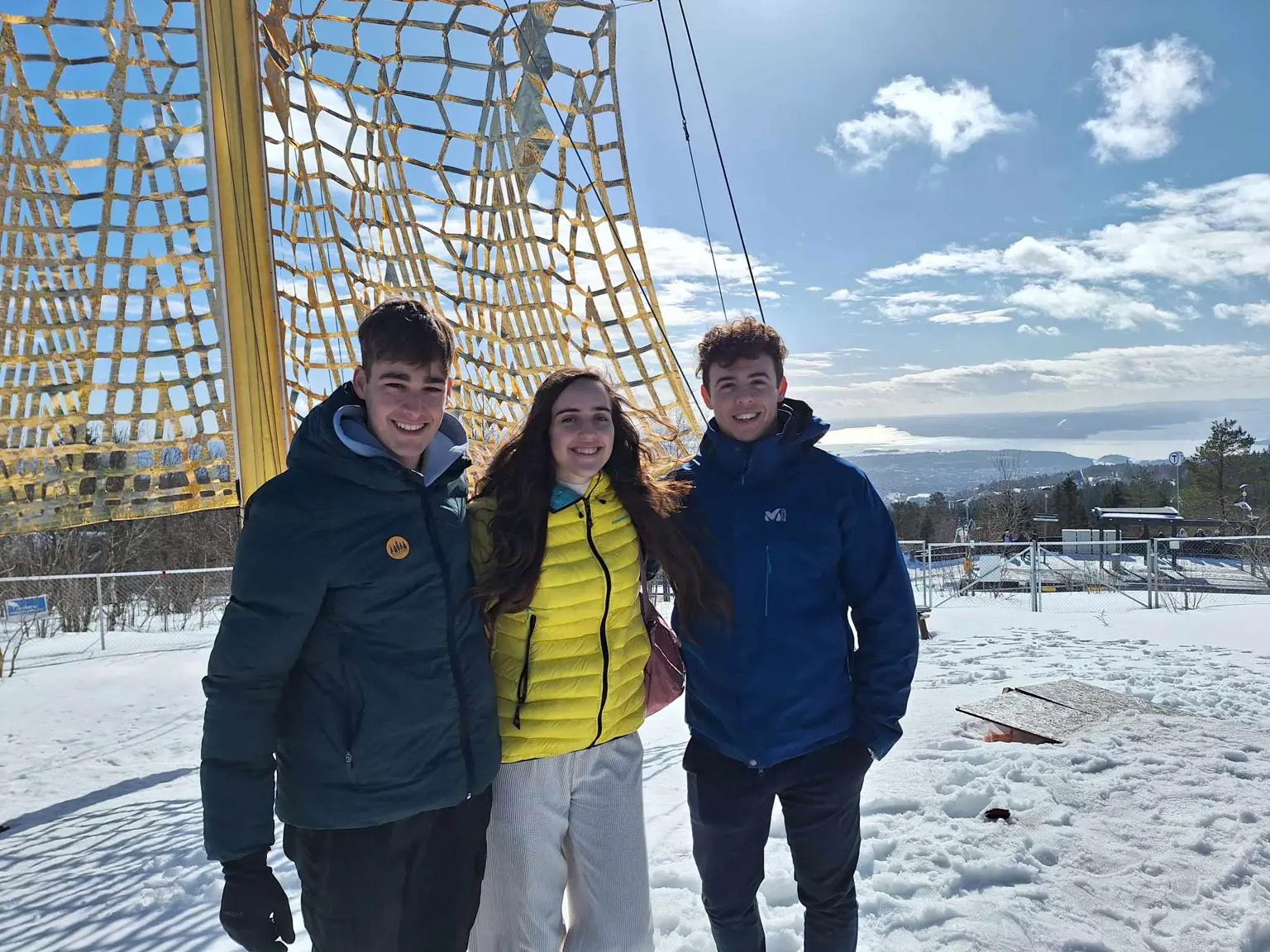 Three young students smiling into the camera