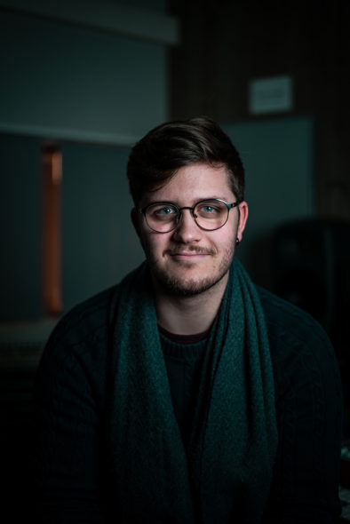Sindre Steige stirrer rett inn i kameraet i et relativt mørkt rom.