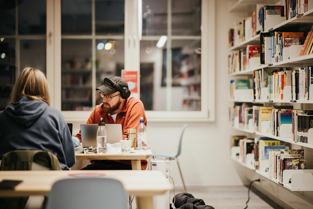 Foto av studenter på bibliotek.