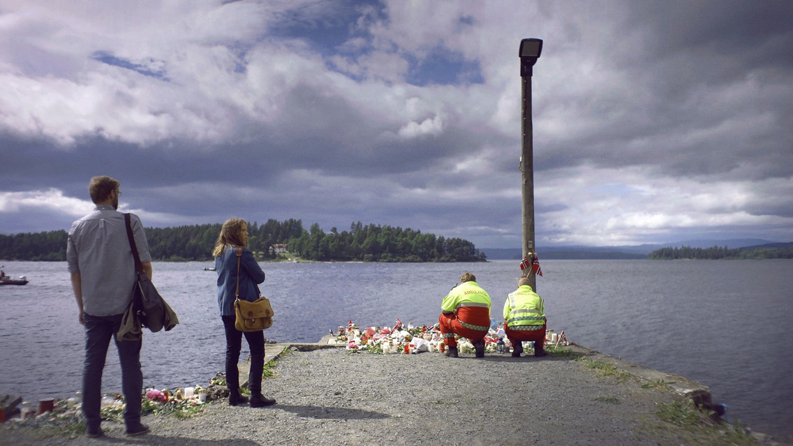 Foto av mennesker som legger ned blomster på en kai.