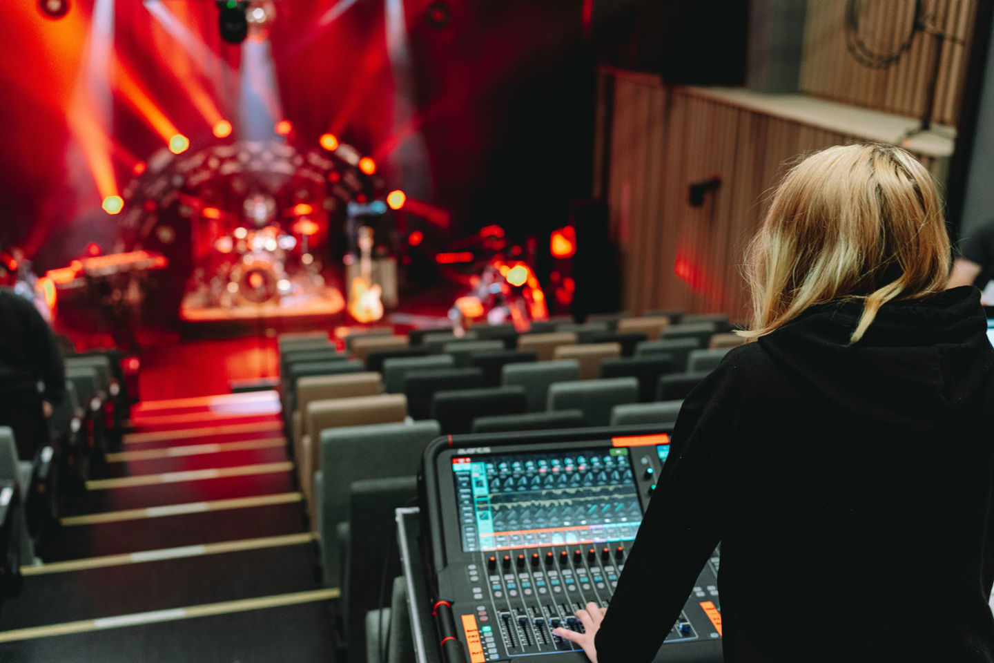 Student står ved miksepult og ser ned på en stor konsertscene.