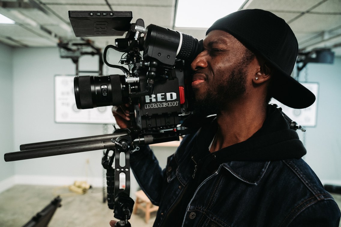 Mann med stort filmkamera på skulderen
