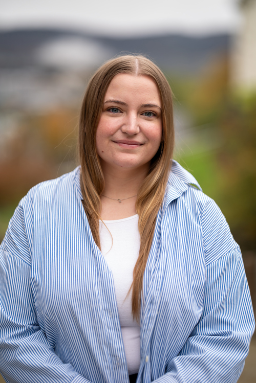 Sandra Eide i blå skjorte smiler til kamera.