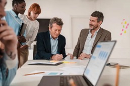 En eldre mann med kollegaer på kontoret