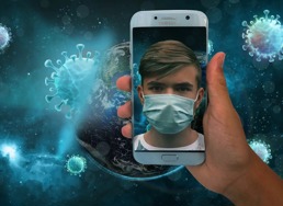 En telefon som viser en gutt med ansiktsmaske foran et bakgrunnsbilde hvor jorden blir angrepet av et virus