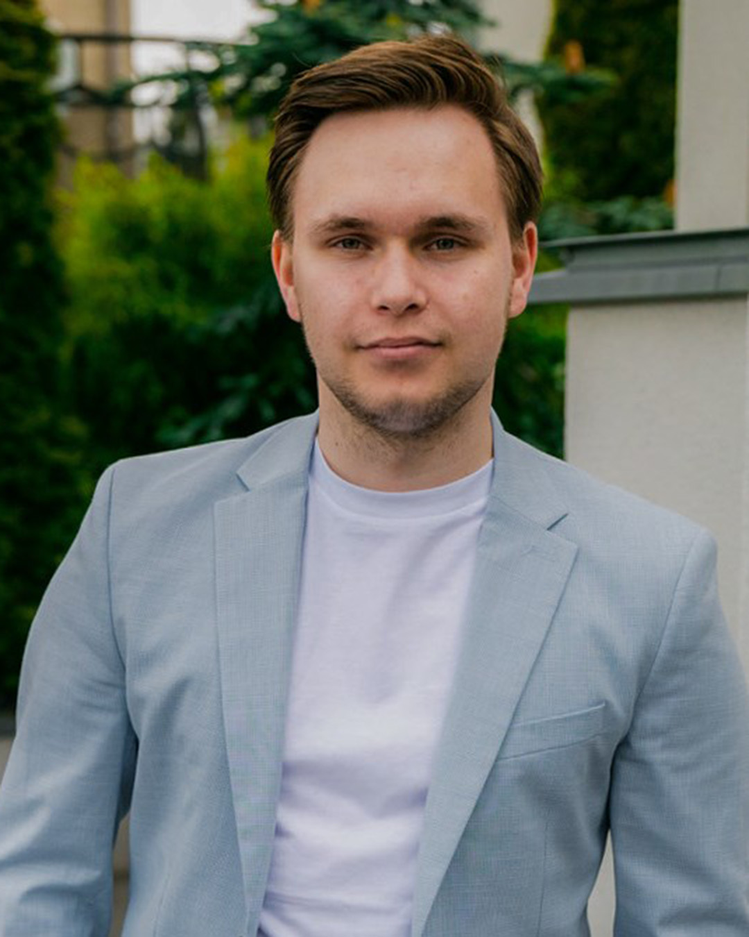 Vetle Hofstad har kort hår og har på seg en lyseblå dressjakke med hvit t-skjorte under.