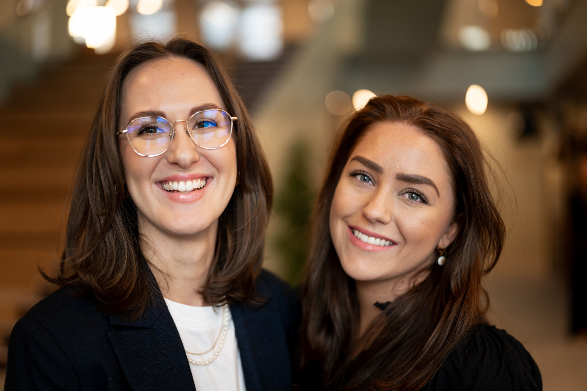 Frida Våraker til venstre og Live-Marie Torgersen til høyre. Begge smiler og har langt, mørkt hår, men Frida har briller og Live-Marie er ti centimeter lavere enn Frida.