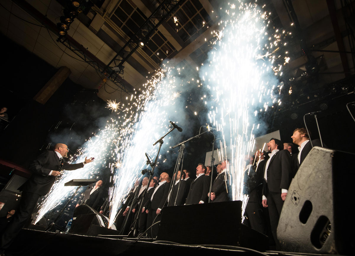 Kor synger mens det spruter opp pyroeffekter langs scenekanten.