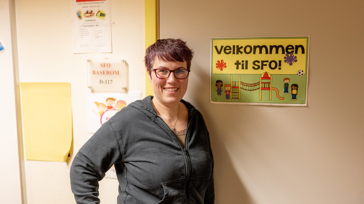 Pedagog på sin arbeidsplass smiler i kamera