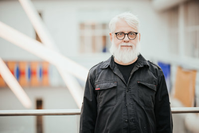 Godt voksen mann med stort hvitt skjegg og briller.