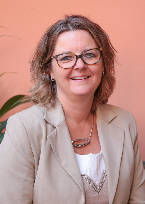 Rektor ved Fagskolen Kristiania, Annelise Kiønig, har halvlangt hår, briller, beige dressjakke og en hvit bluse. Hun har et stort sølvsmykke rundt halsen. 