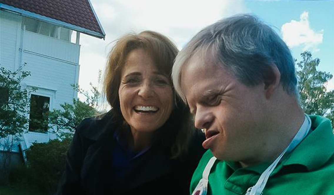 Søster ler sammen med lillebror.