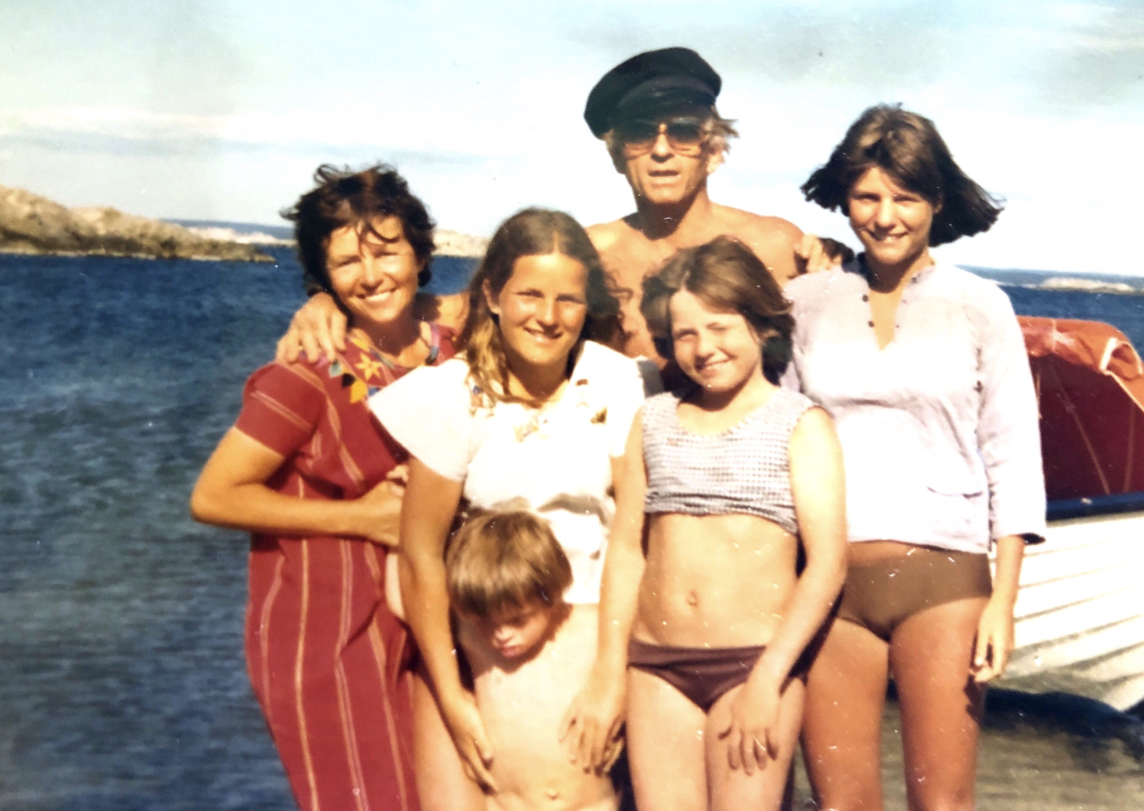 Familie på seks på båttur langs sjøen.