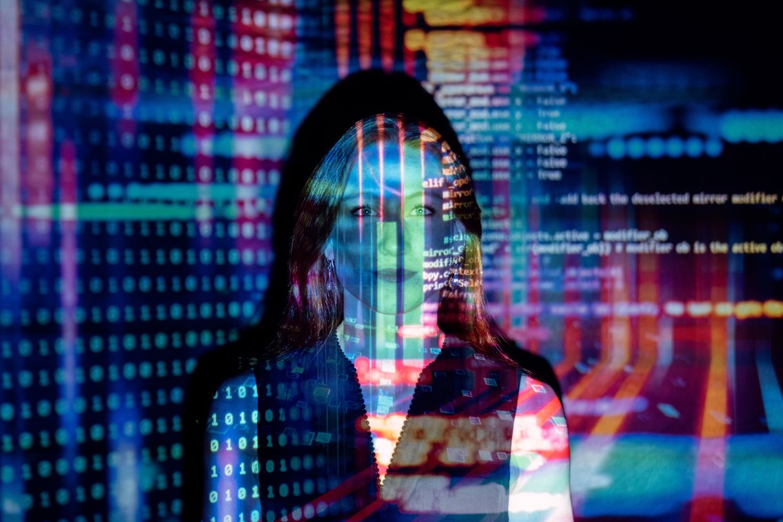 Kvinne med dataskrift over ansiktet og på veggen rundt seg