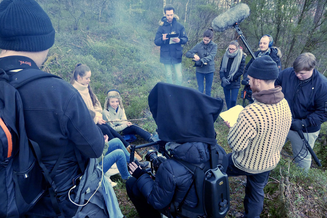 En gruppe mennesker i naturlandskap med mikrofon