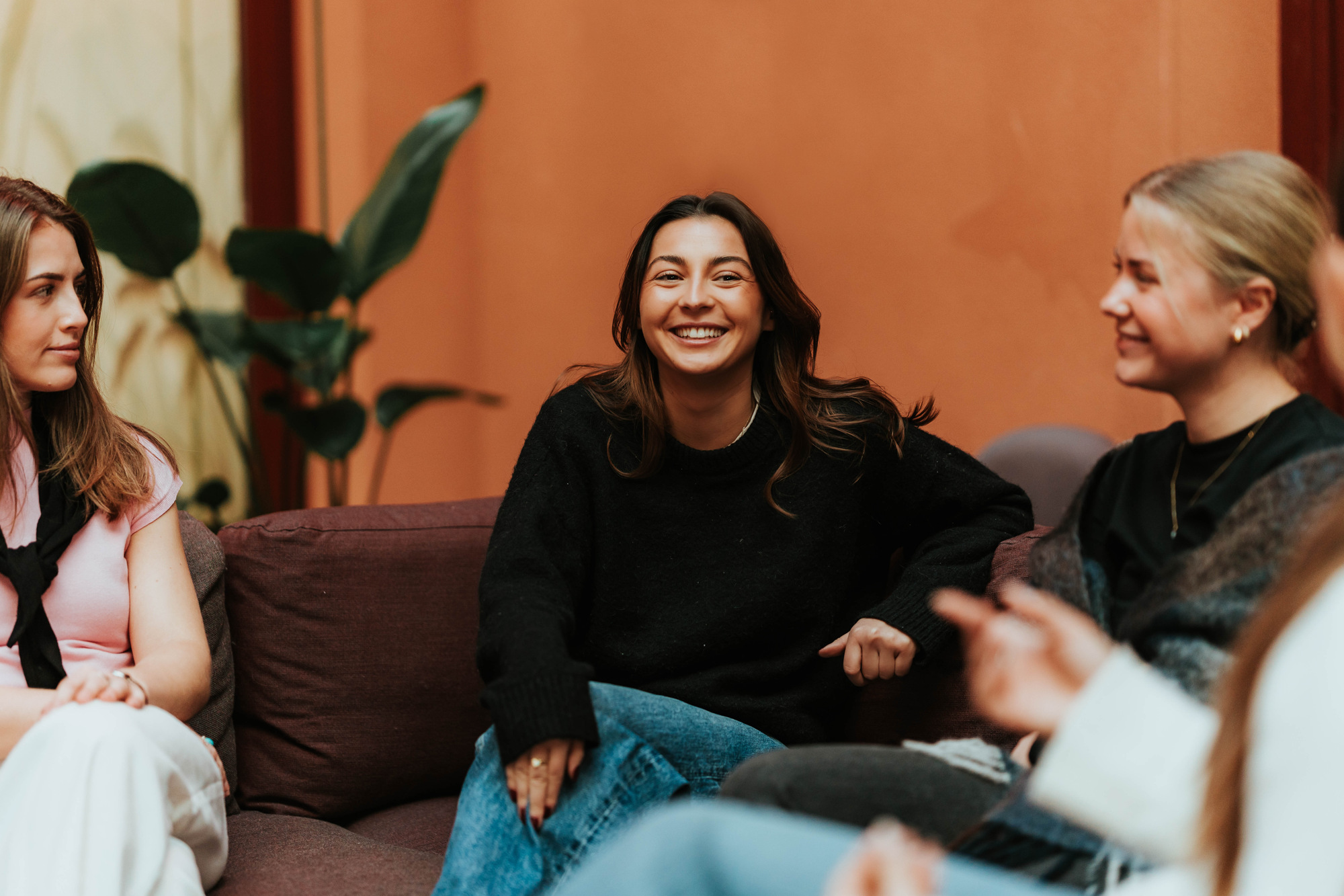 Studenter som sitter i en sofa på campus og prater med hverandre.