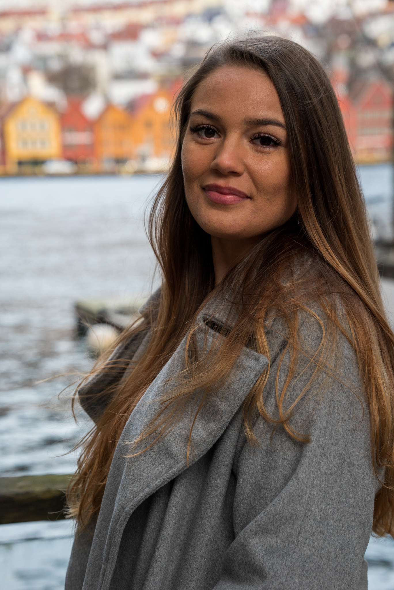 Portrett av Camilla Broderstad  som står ute med Bryggen i Bergen i bakgrunnen. 