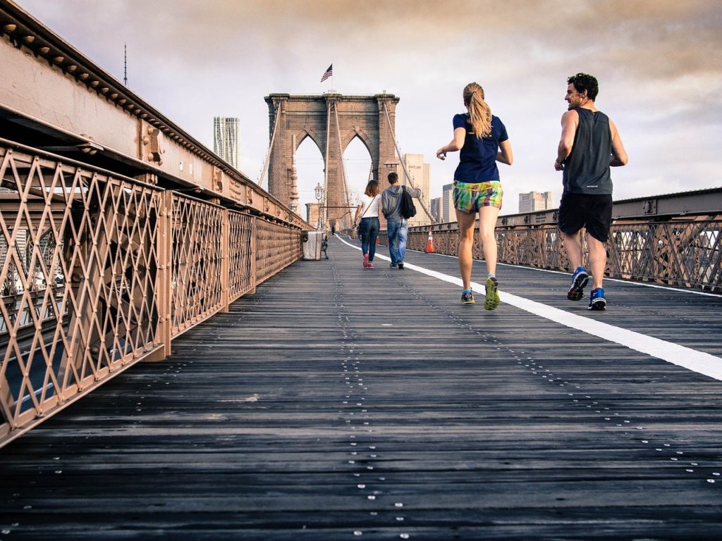 Mennesker som jogger over en bro