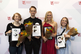 Foto av fire studenter som holder blomsterbuketter og diplomer.