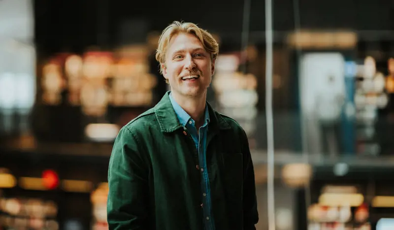 Mann smiler til kamera.