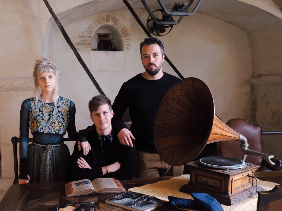 Foto av artist Aurora, Benjamin Langeland og Stian Servoss. I bildet står en gammel grammofon på et skrivebord.. 
