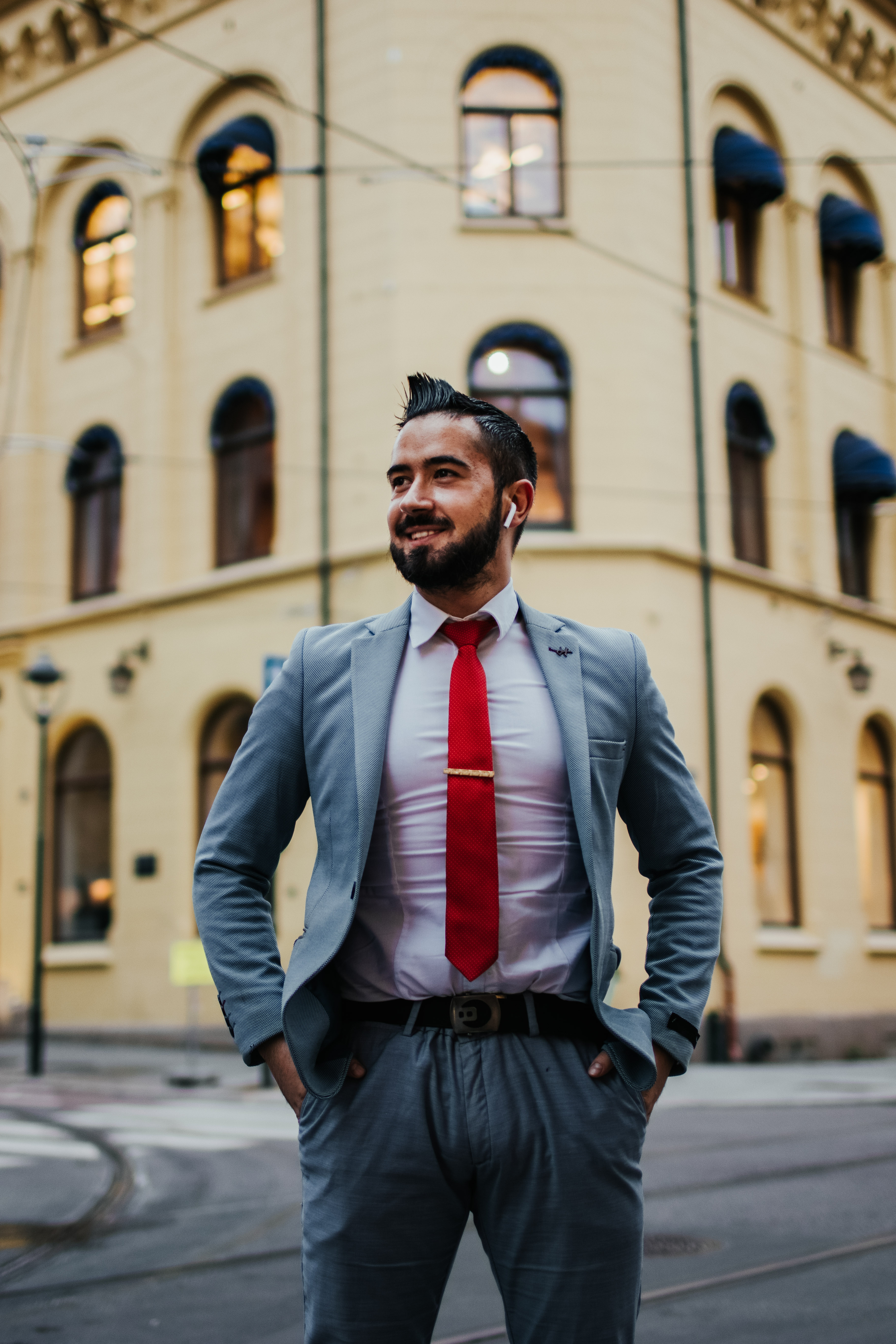 Hotelledelsestudent Zlatko iført blå dressjakke, skjorte og slips. Han står foran Høyskolen Kristiania campus kvadraturen i Oslo.