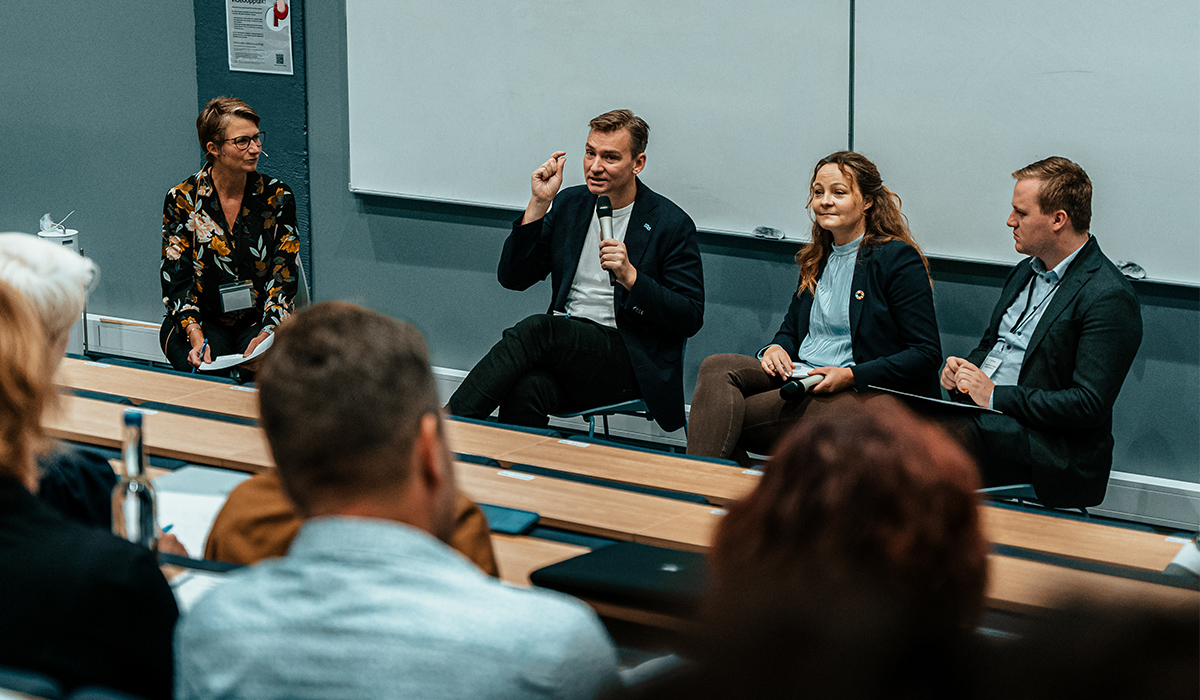 Bilde av fire deltakere i en paneldebatt.