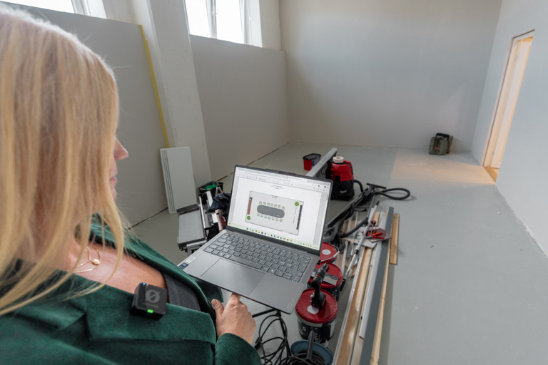 Person holder en PC med 3d-visualisering i et rom