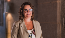 Rektor Annelise Kiønig smiler mot kamera. Hun har halvlangt brunt hår, briller og beige bluse.