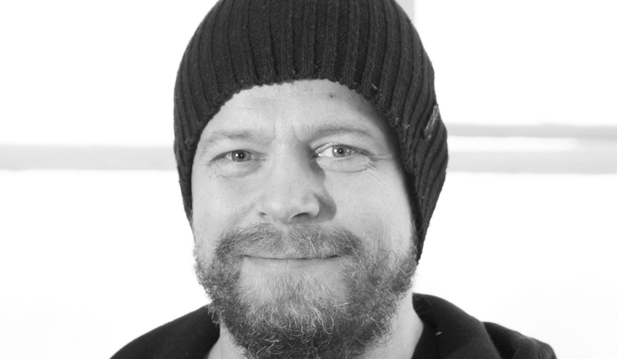 Portrettfotografi av Kåre Såtvedt med lue i sort hvitt