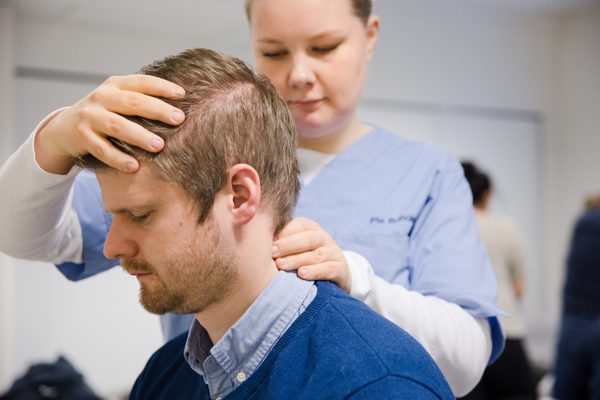 Osteopat som gjør en nakkejustering på en pasient