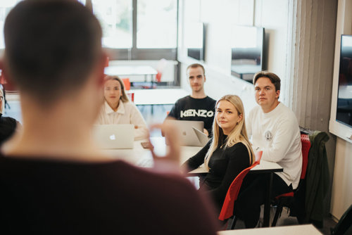 Foto av mann som underviser studenter.