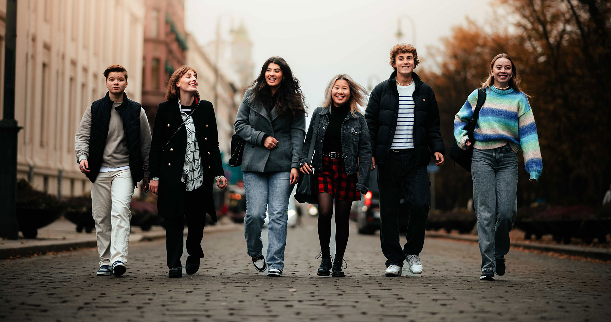 Seks studenter går ute på gaten. 
