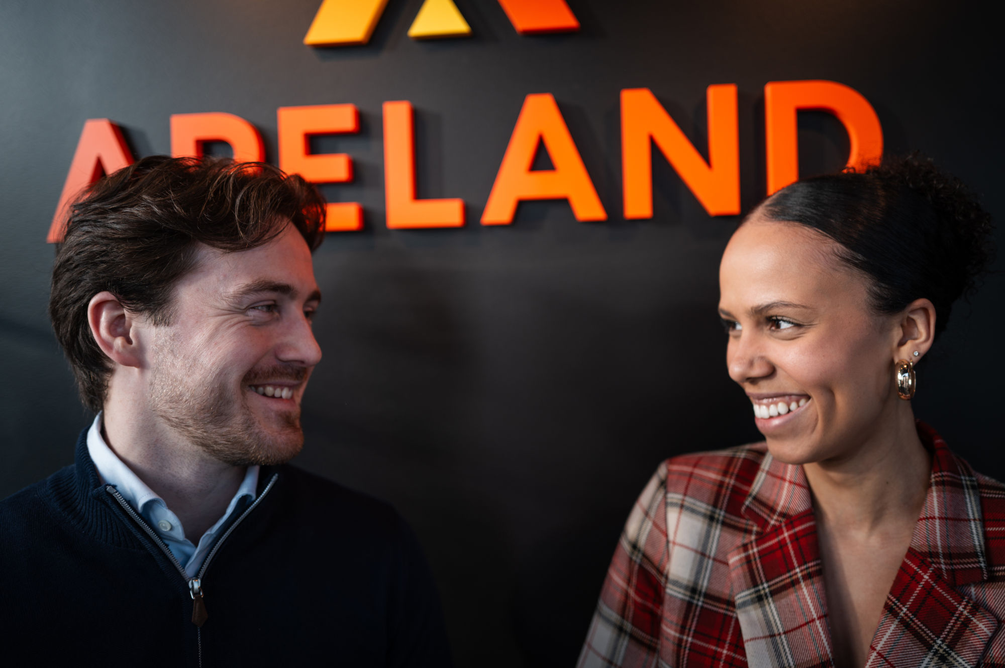 David og Amanda fotografert foran et skilt hvor det står "Apeland".