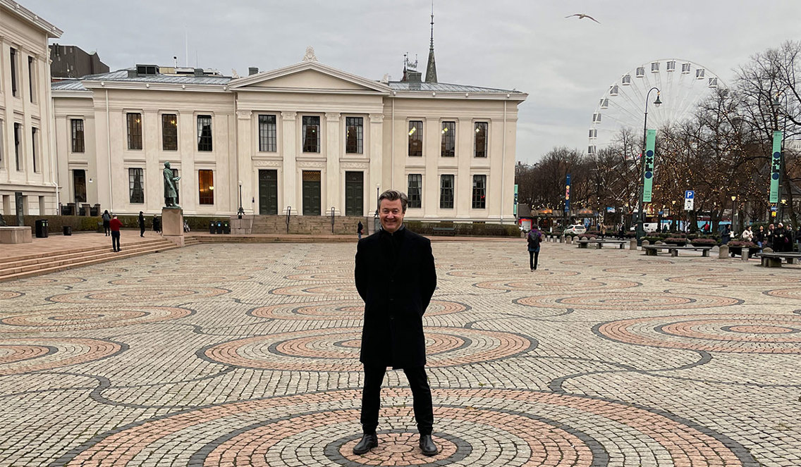 Svartkledd mann står på åpen plass ved Karl Johans gate.